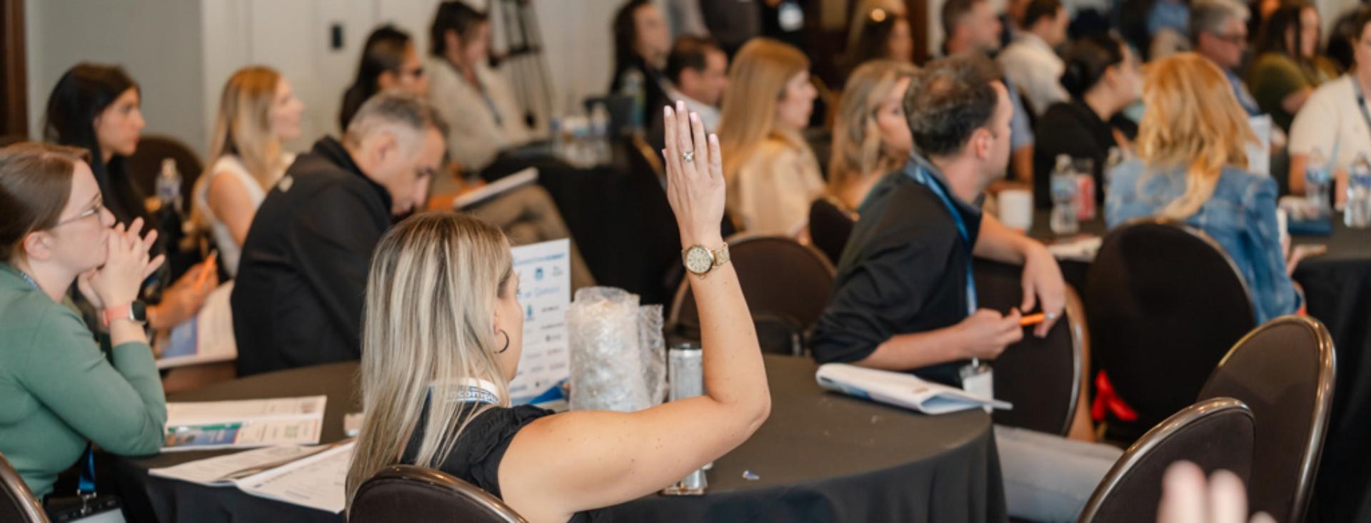 Picture of people in room raising hand